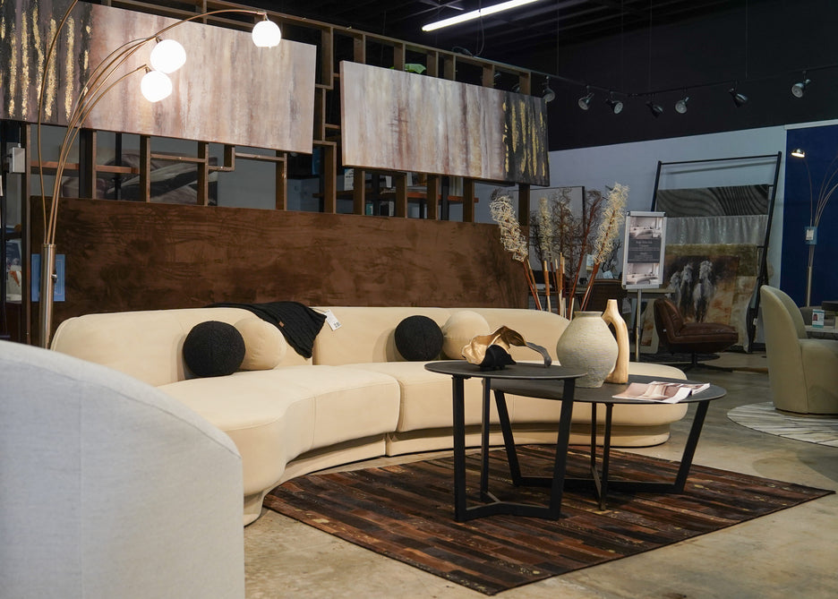 Modern cream color velvet sectional with black coffee tables in Caravana Furniture Showroom