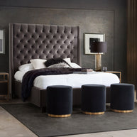 Modern bedroom with a large tufted headboard, white bedding, and dark gray walls.