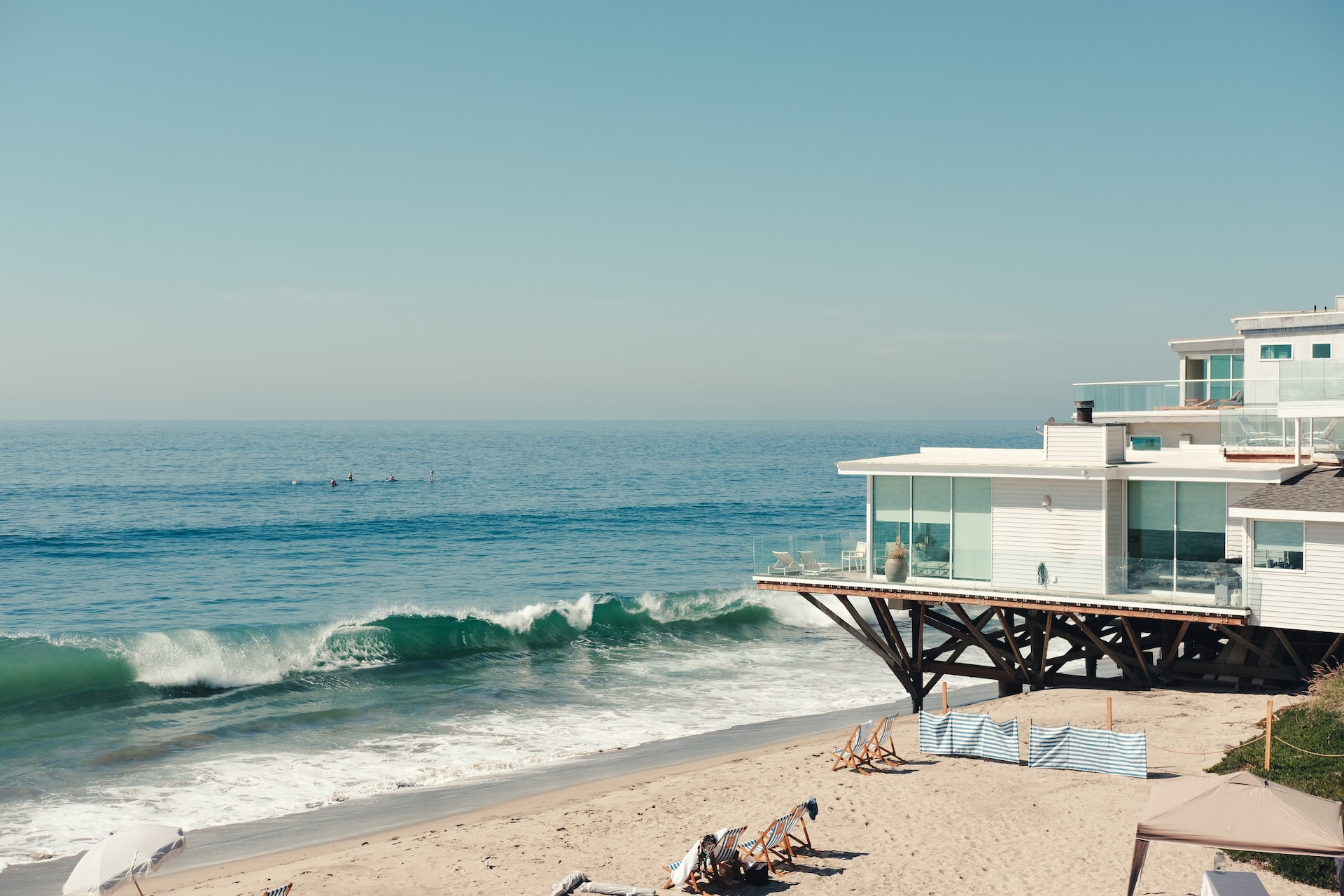 A modern white house on the shore of a wavy beach